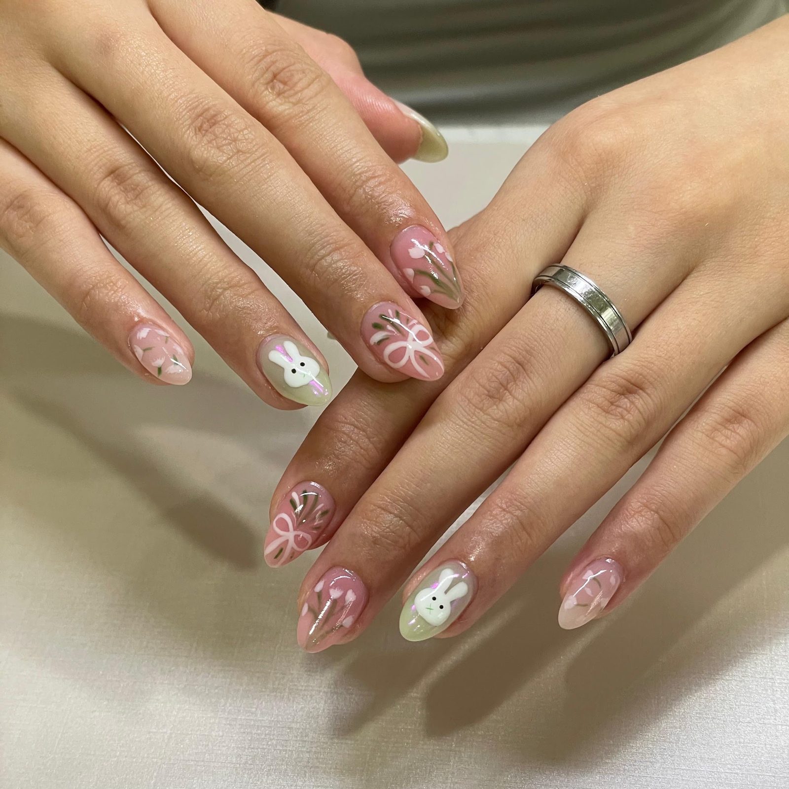 Delicate floral and bow nail art on a nude base